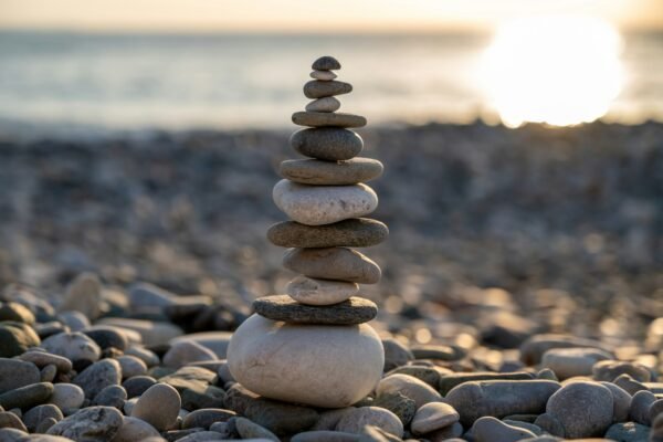 Stack of balanced stones on a beach at sunset representing a balanced life