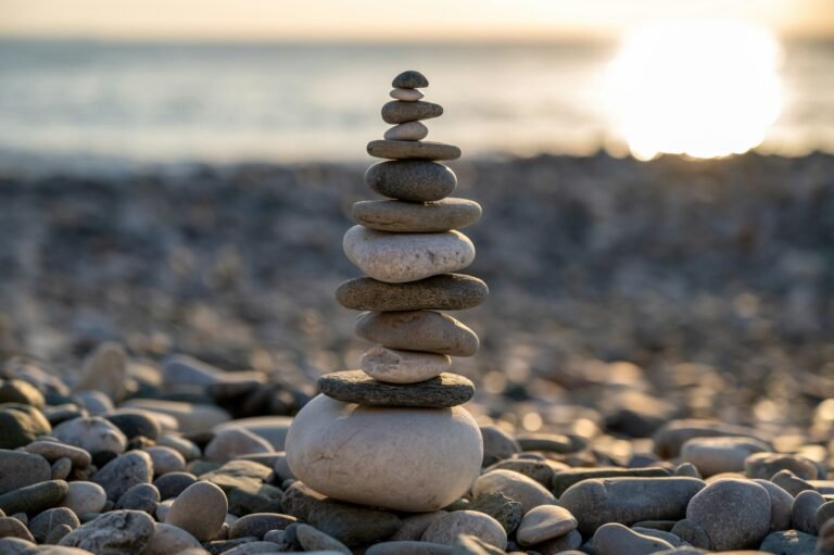 Stack of balanced stones on a beach at sunset representing a balanced life