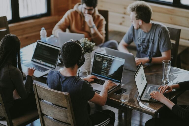 Group of colleagues using laptops together representing business technology