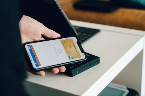 Person holding a smartphone over a card reader for contactless payment