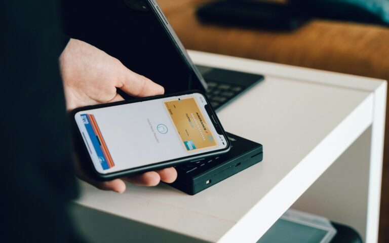 Person holding a smartphone over a card reader for contactless payment