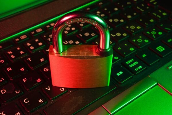 Red padlock on black computer keyboard representing cybersecurity
