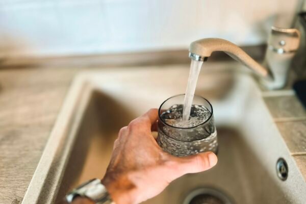Hand holding a glass of water representing small healthy lifestyle changes