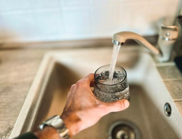 Hand holding a glass of water representing small healthy lifestyle changes